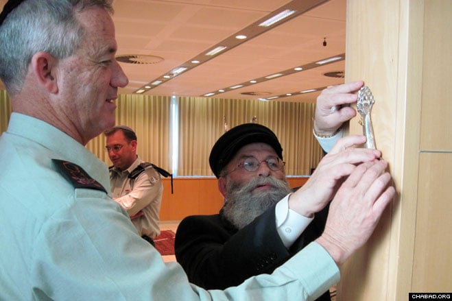 Rabbi Yaakov Gloiberman, director of the Chabad-Lubavitch run Yad B’Yad charity, greets Israel Defense Force spokesman Brig. Gen. Avi Benayahu at the Tel Aviv ceremony celebrating the promotion of Maj. Gen. Benny Gantz as the army’s 20th chief of staff.